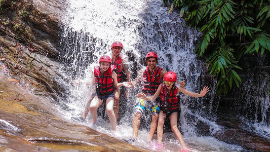 Children in life vests playing at a waterfall