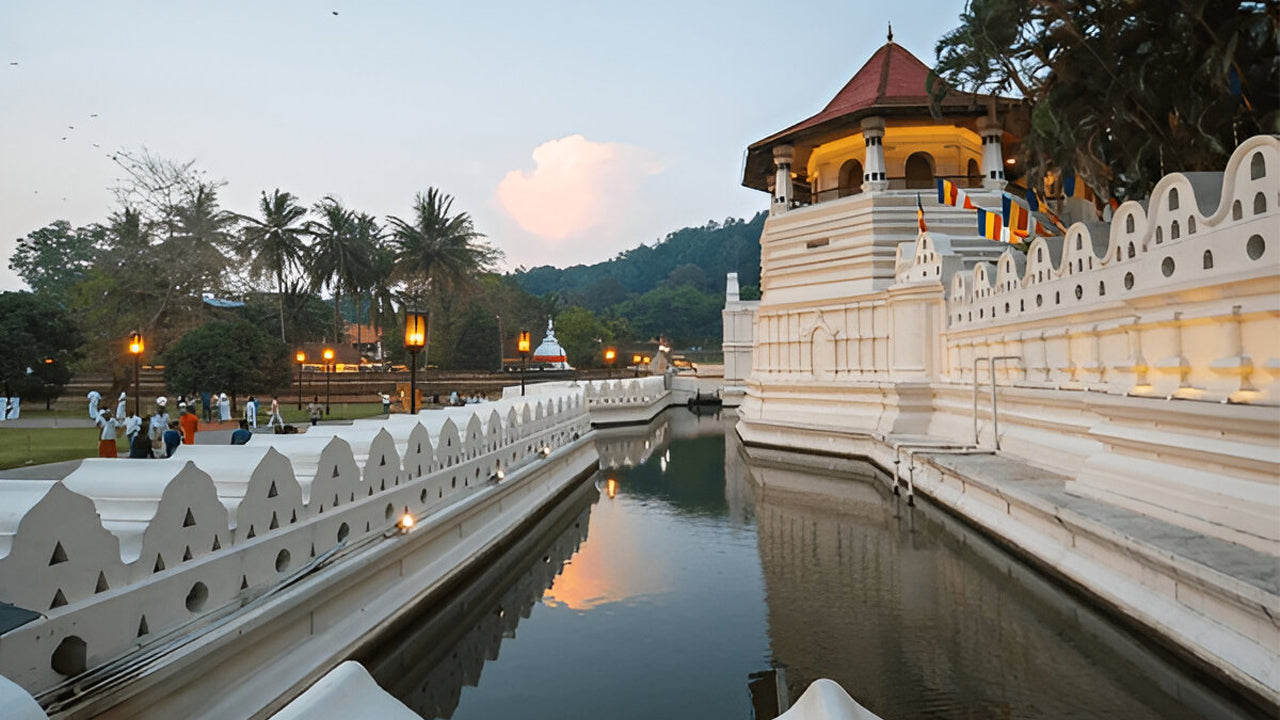 Traditional temple with water body and palm trees at dusk